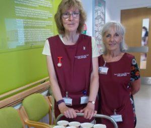 Volunteers smiling with trolly of drinks