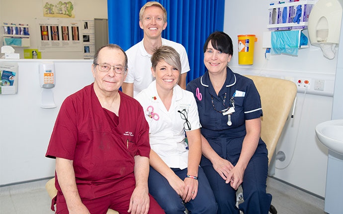 Medical staff smiling on a hospital bed