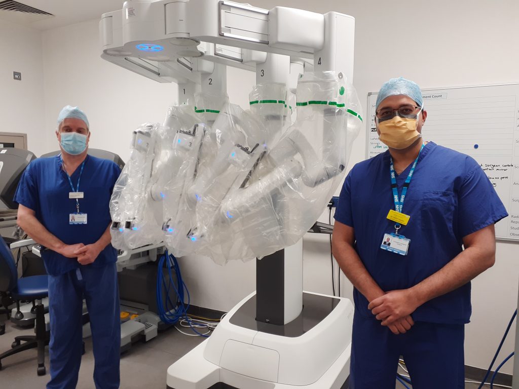 Richard Hammond, East and North Hertfordshire NHS Trust's managing director for planned care, pictured with urology consultant Mr Nikhil Vasdev next to the robot on the day of the first operation