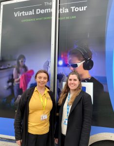 A picture of two women outside the Virtual Dementia Tour bus, taken at Lister Hospital in Stevenage, Hertfordshire. Sonia, pictured left is a volunteer at the East and North Hertfordshire NHS Trust, and Molly, pictured right, works as a volunteer co-ordinator.