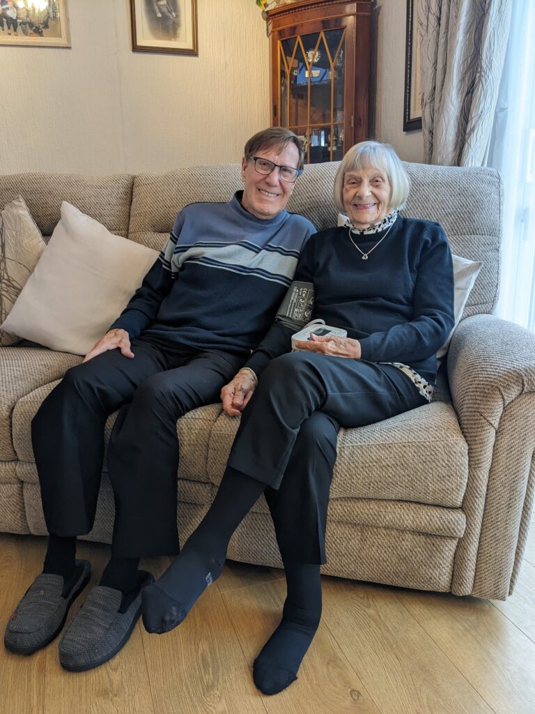 Edna, pictured alongside her husband Bob at their home. Edna is holding a piece of equipment used as part of her remote monitoring Hospital at Home programme.