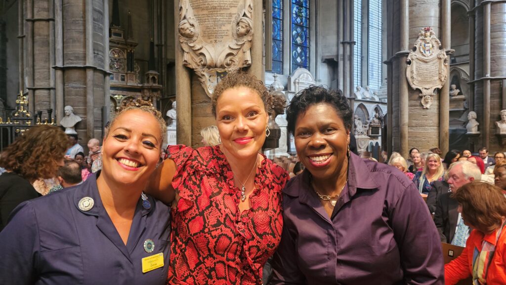 A photograph of Dionne Thompson alongside a colleague and her sister Bev at the Florence Nightingale Service in Westminster Abbey. 