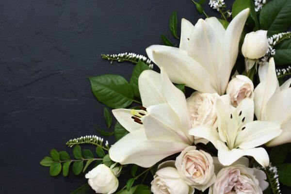 Lilies and roses against a black background
