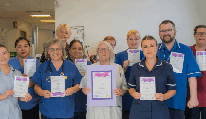 A photograph taken of members of the ACC and MDU team, they are holding Purple Pledge certificates.