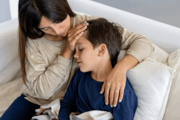 A mother soothing her young child who is unwell.