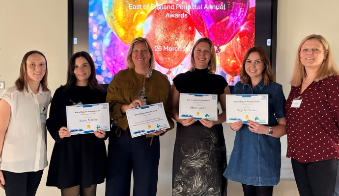 A group of staff from East and North Hertfordshire Teaching NHS Trust pose for a photograph during a celebration event.