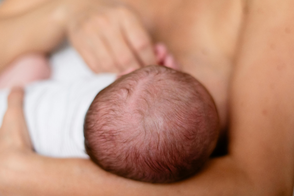 A royalty-free image of a newborn baby being cradled.