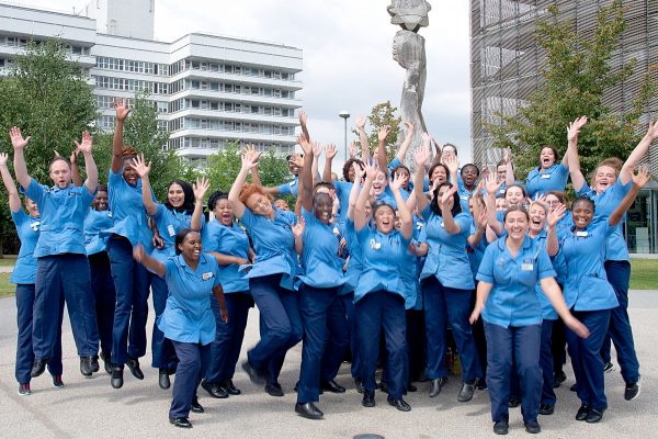 Enthusiastic nursing student team jumping in the air celebrating