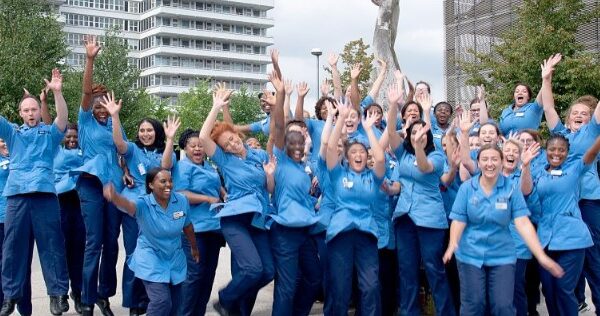This photo features a large group of our student nurses in the Lister plaza, all throwing their hands in the air