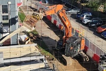 A demolition vehicle beginning works at St Albans - showing building being demolished