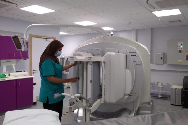 A picture of a staff member next to a SPECT-CT